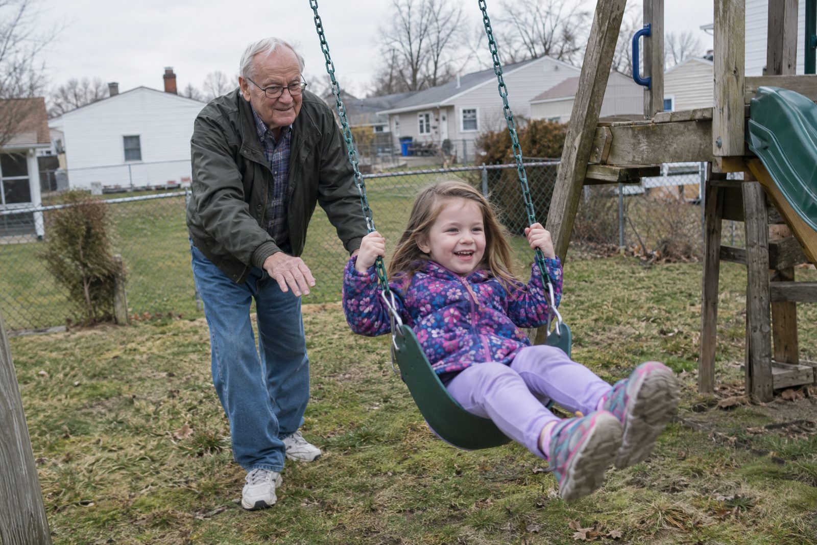A grandfather and granddaughter planting a tree together